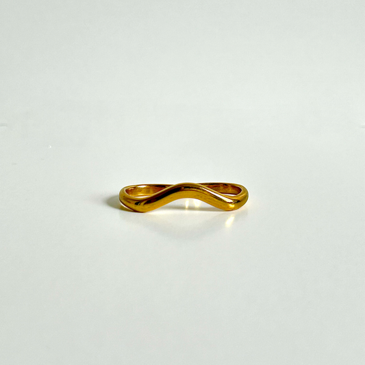 Gold ring with a unique design on a light gray background
