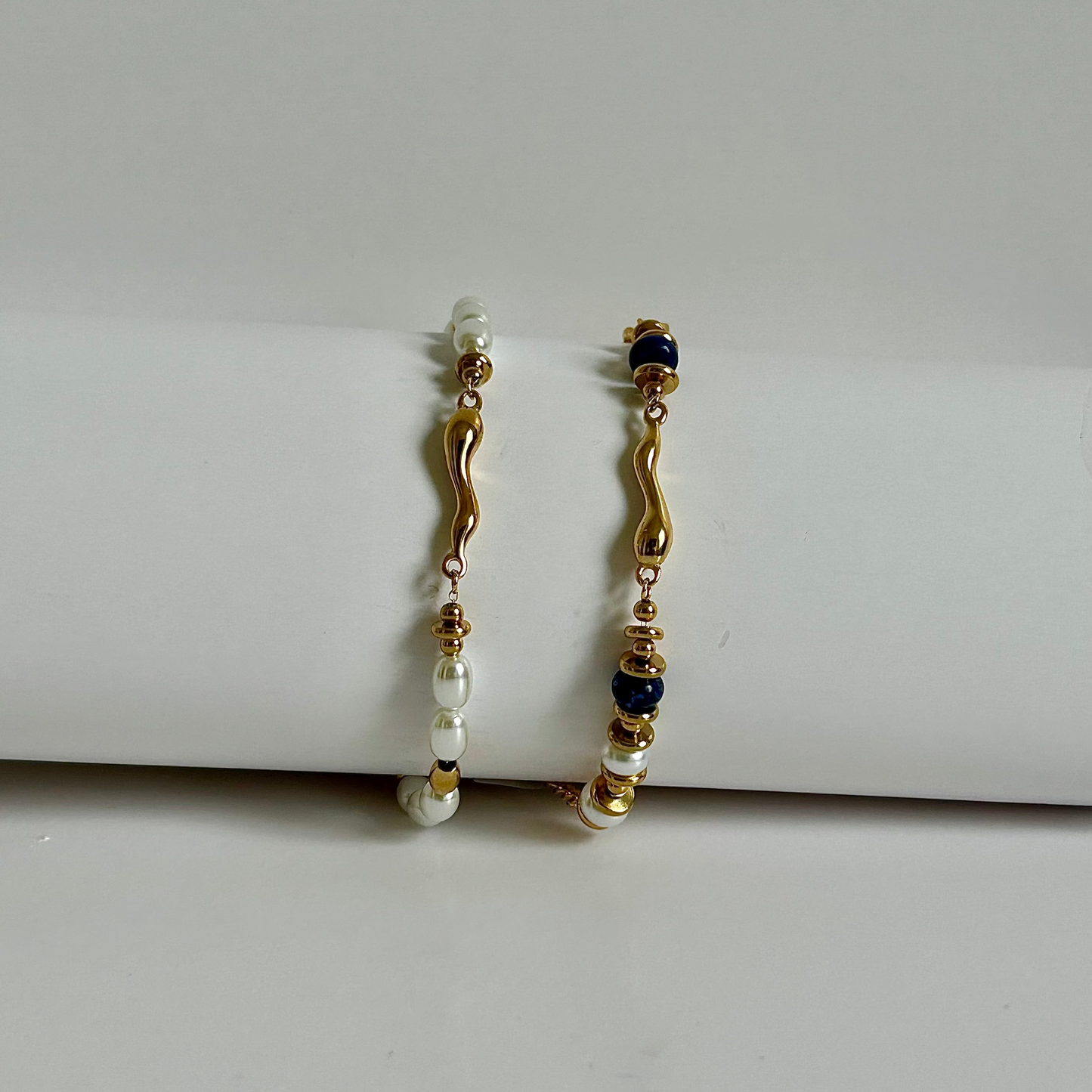 Pair of gold and pearl earrings on a white surface