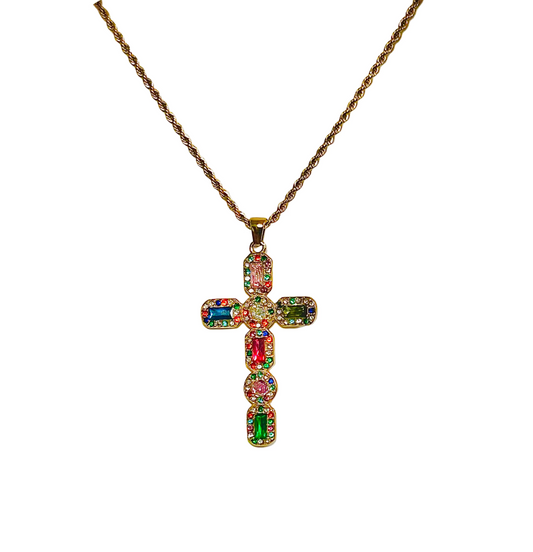 Multicolored gemstone cross pendant on a gold chain against a white background