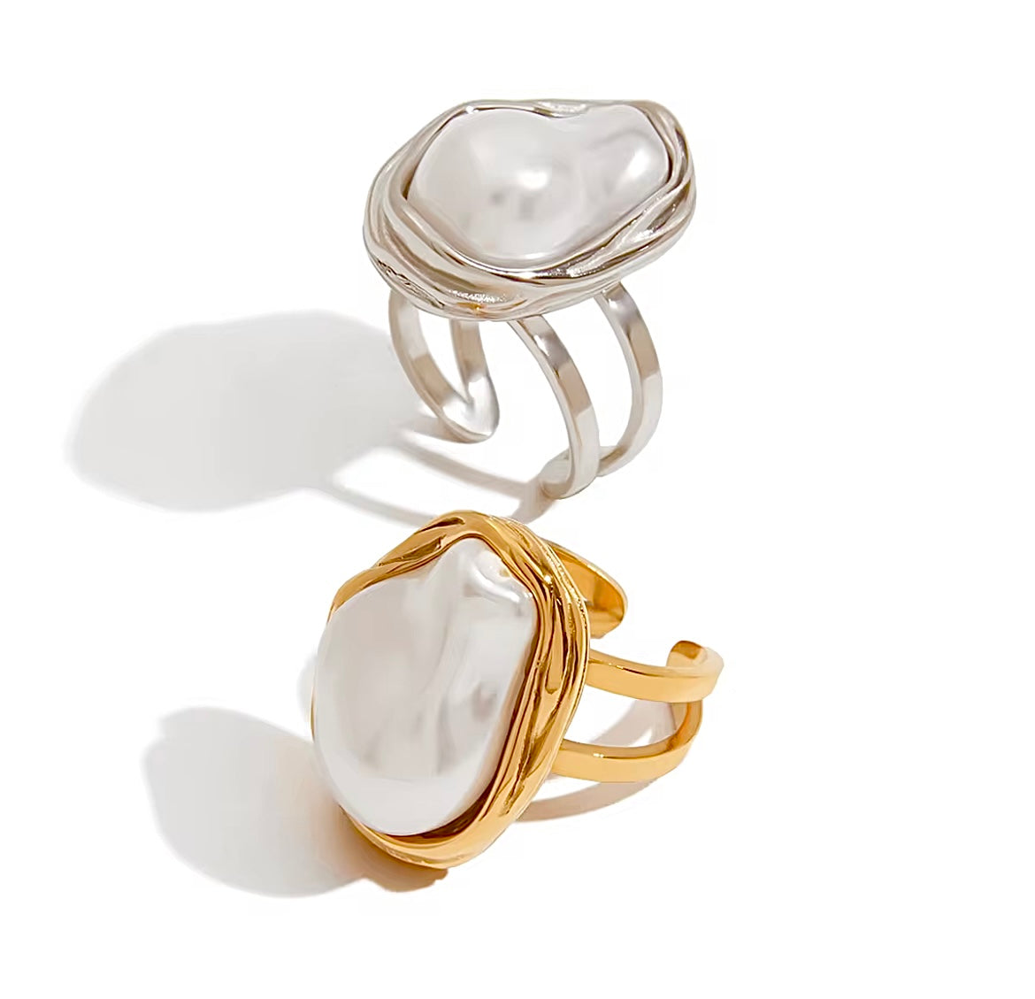 Two pearl-encrusted rings, one gold and one silver, on a white background.