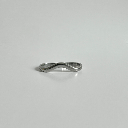 Silver ring with a wavy design on a light gray background